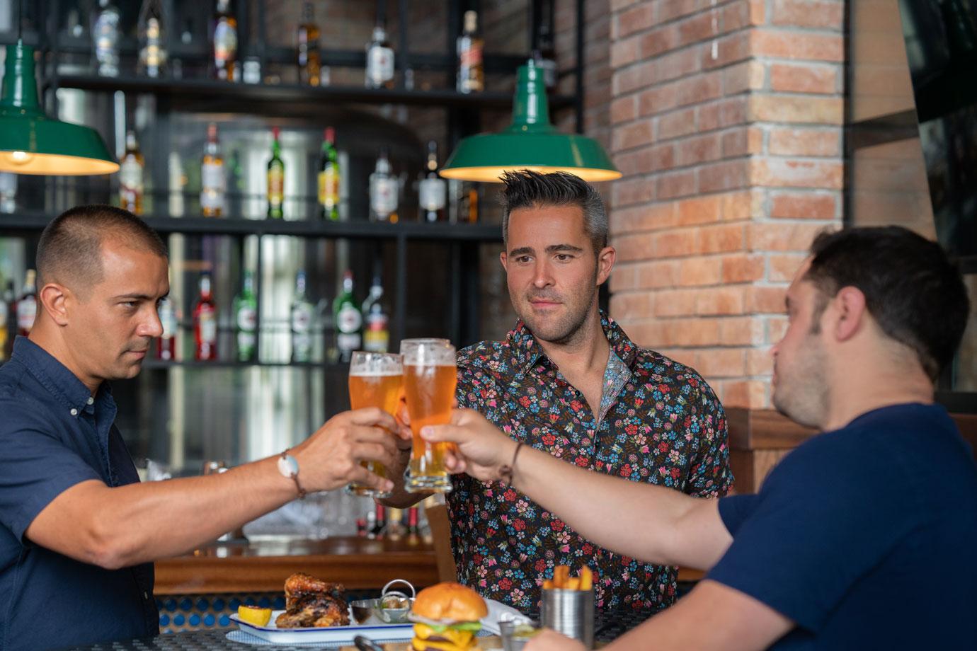 three men toasting with beer in oktoberfest festival 