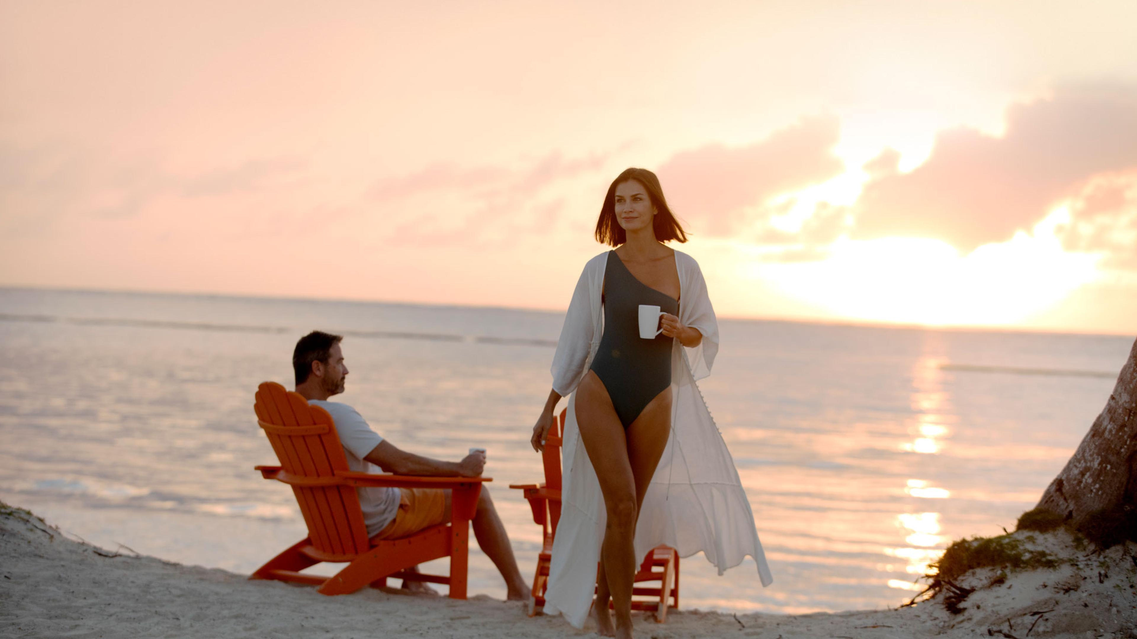 a couple on a beach at sunset